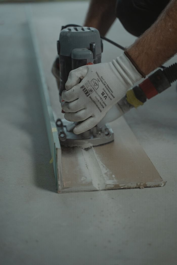 Focused view of hands operating a hand drill, showcasing carpentry skills and precision.