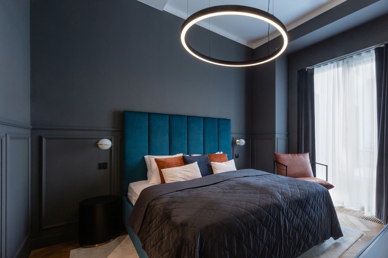 Stylish modern bedroom in Prague featuring a contemporary ring light and cozy bedding.